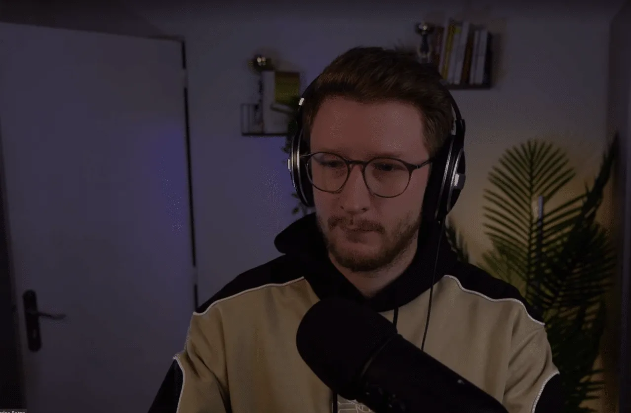 Charles Baras au casque devant son micro, en train de travailler